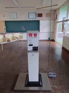 一般的兌幣機與長椅,兌幣機放在磅秤上,當 1000 元鈔票換成 10 個 100 元硬幣時,旁邊的數字會產生變化
