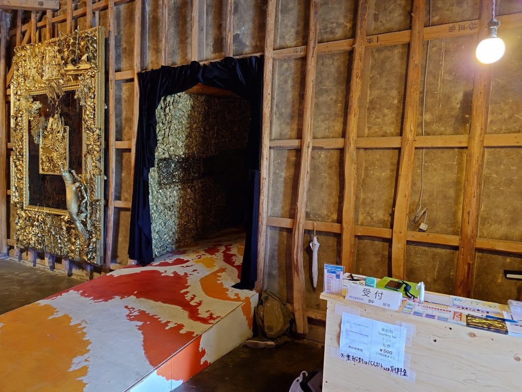 「黄金の海に消えた船」的入口與接待櫃台，櫃台上貼有乘船須另外付費的多國語言的告示